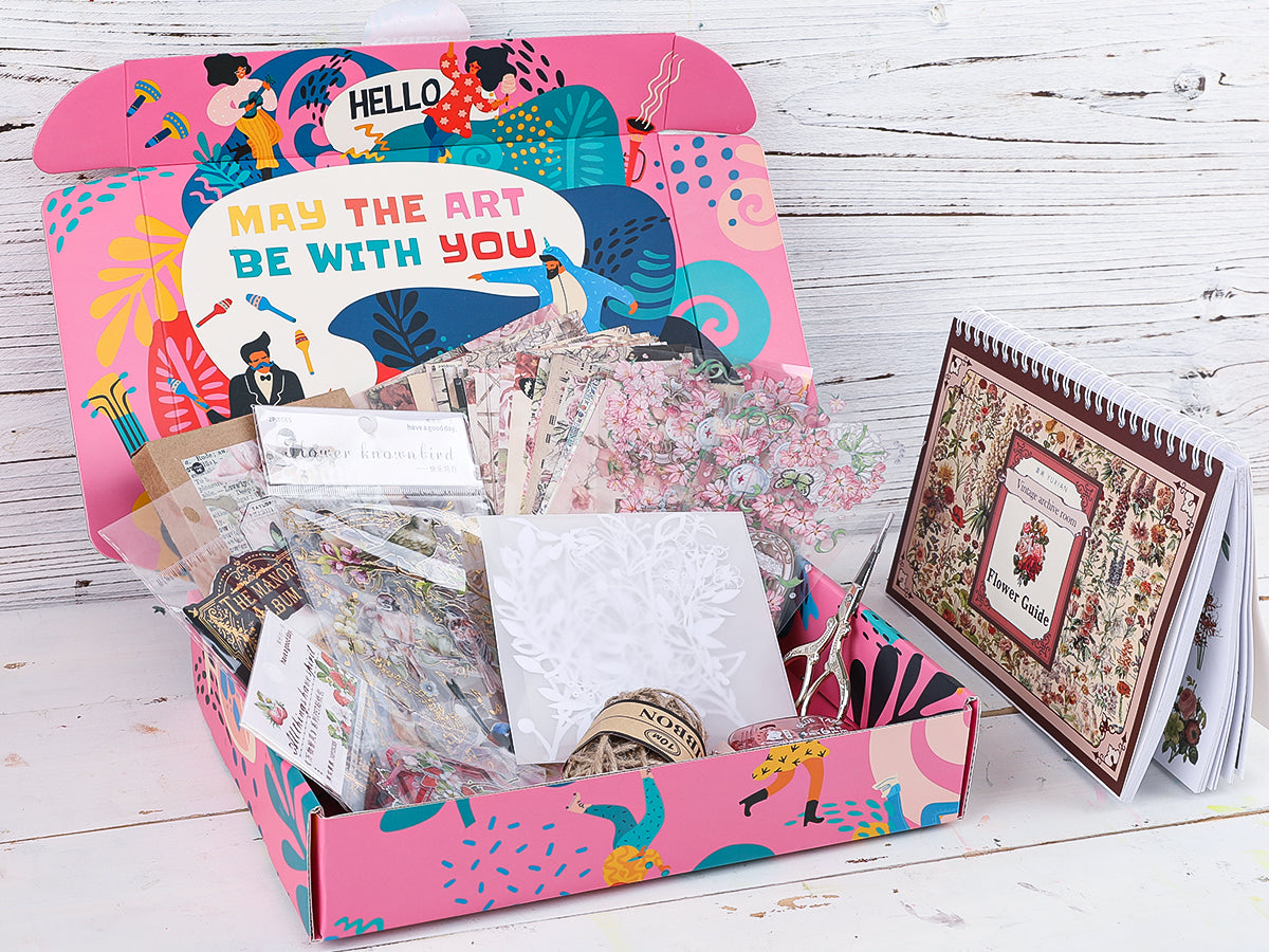 Arts and crafts supplies box with floral stickers, washi tape, scissors, and a vintage flower guide