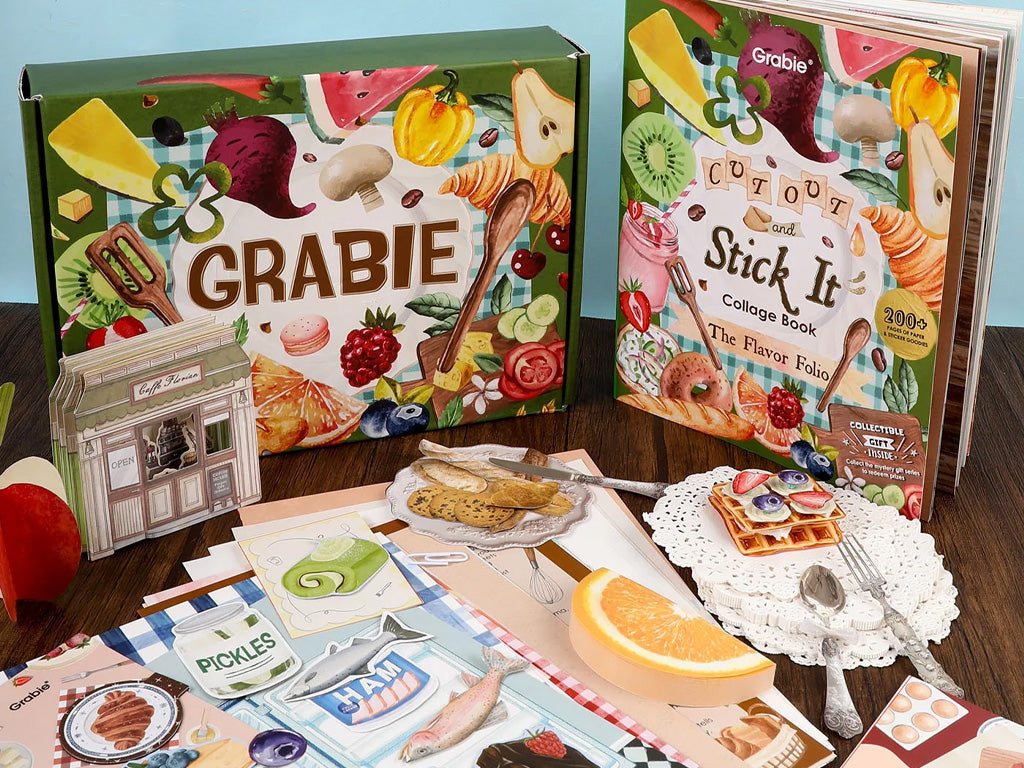 Cutout collage book, stationery, and paper craft supplies with food designs on a wooden table