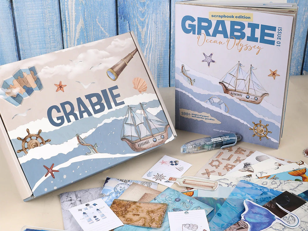 Ocean-themed scrapbook kit with nautical stickers, papers, and art supplies on a table.