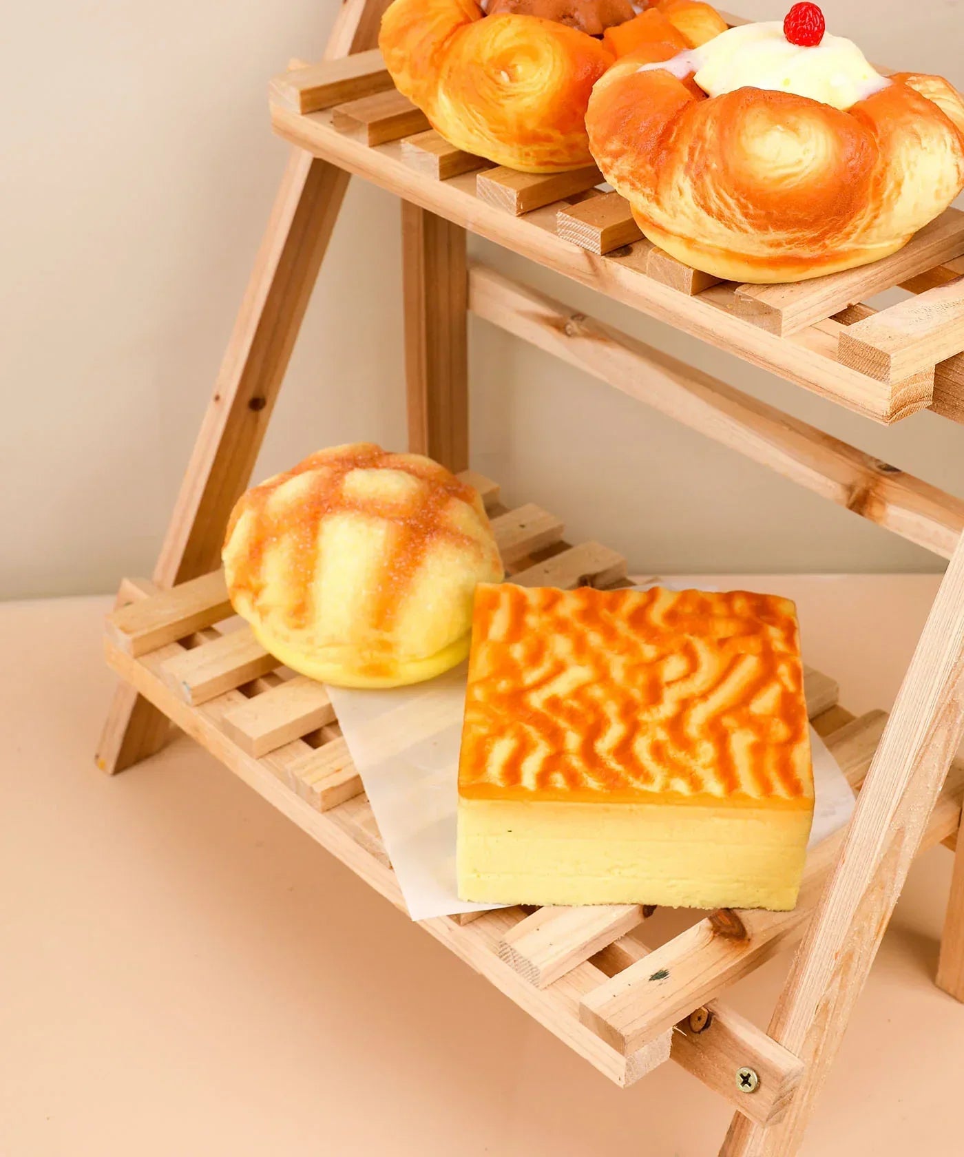 Feel-Good Stress Relief Foam Squishy - Tiger Skin Cake on wooden rack among other squishy desserts in soft warm light