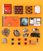 Halloween-Themed Grabie Scrapbook Club Box with stencils, art supplies, themed papers, stamps, and Halloween scrapbook materials.
