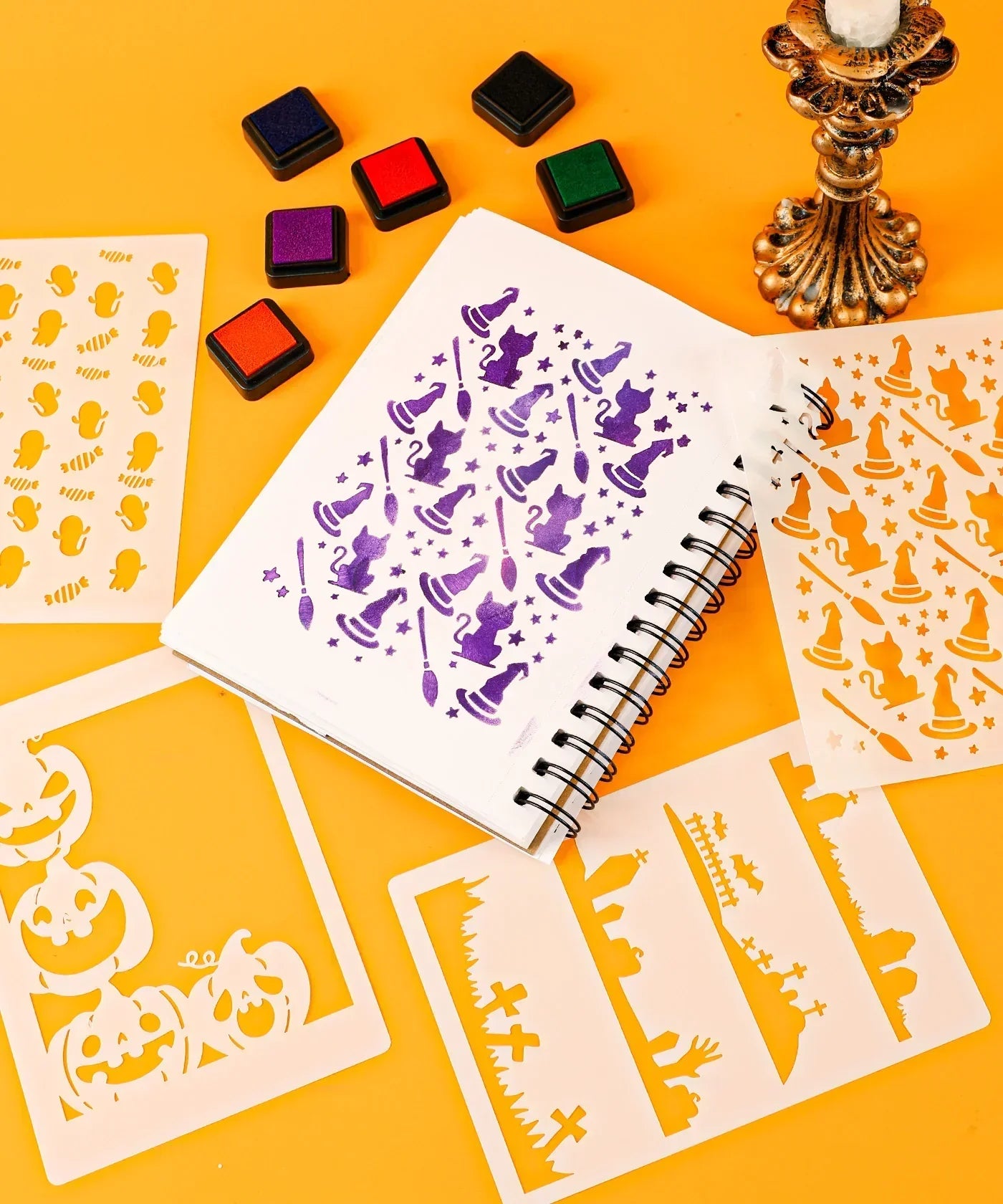 Halloween-Themed Grabie Scrapbook Club Box with stencils, ink pads, and Halloween witch and pumpkin art supplies on orange background