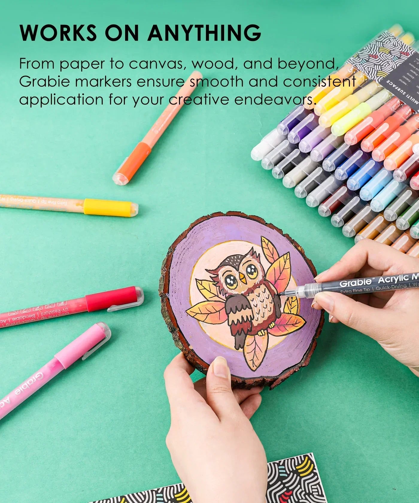 Person coloring an owl design on wood using Extra Fine Tip Acrylic Paint Marker Set of 48 with vibrant marker colors nearby