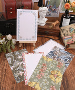 6 Pack Postcards With 6 Matching Envelopes featuring floral and patterned designs displayed on a wooden table with decor.