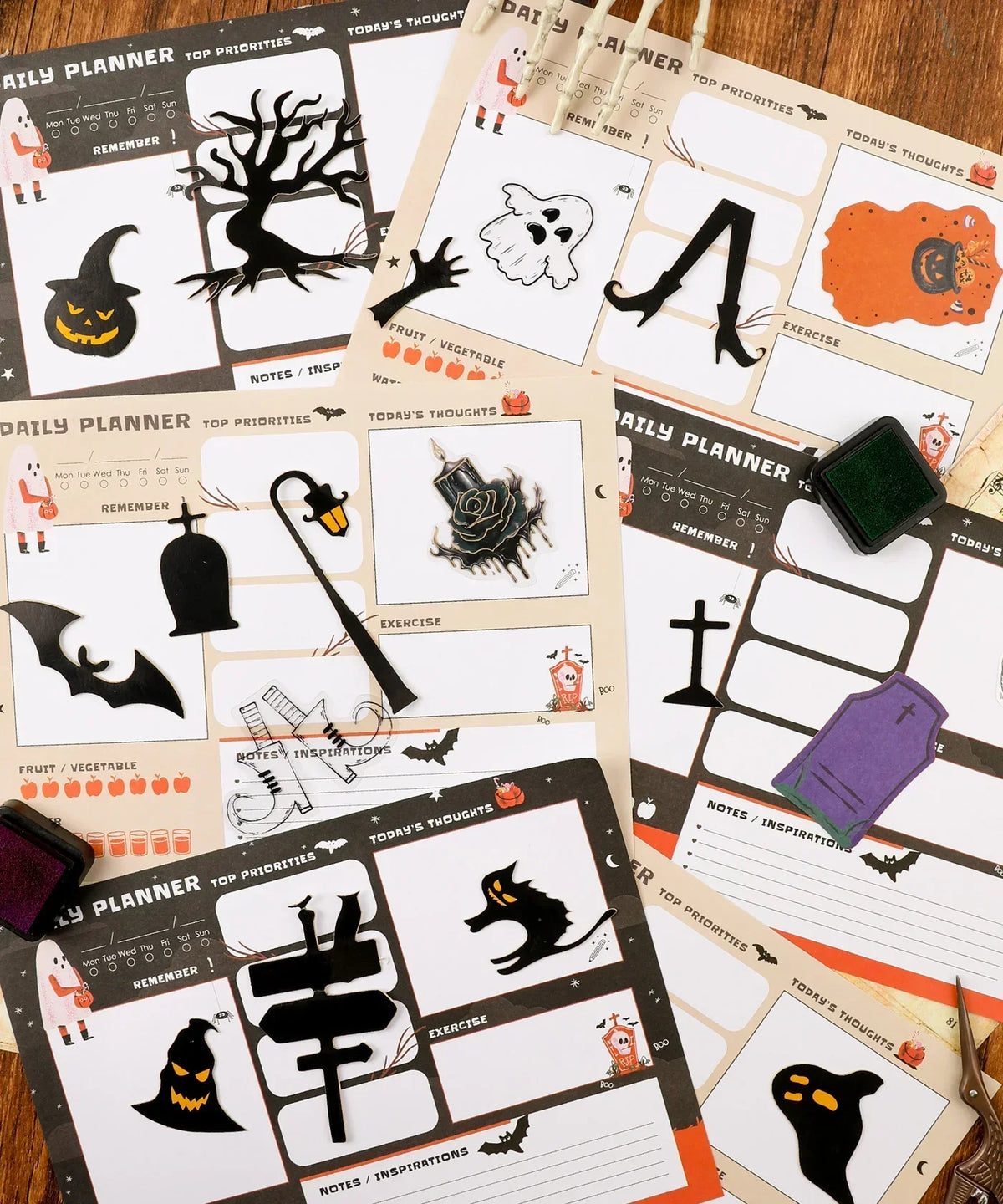 30 sheets Halloween Exclusive Daily Planner with spooky icons and decorative stamps laid out on a wooden surface