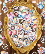52 Pcs Grabie Exclusive Hoppy Easter Sticker Set with colorful eggs, baskets, and floral designs on an ornate gold mirror