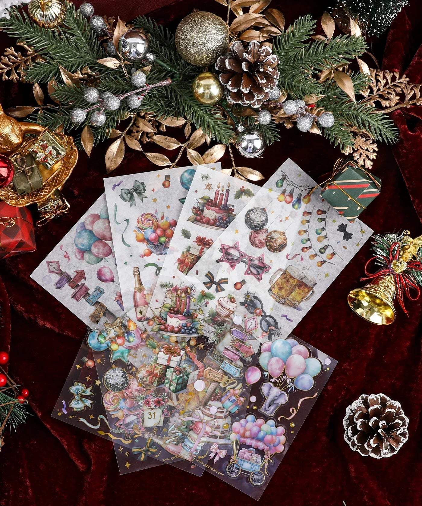 8 Sheets Grabie Exclusive New Year Sticker Set with festive holiday designs on a dark red background with pine cones and ornaments