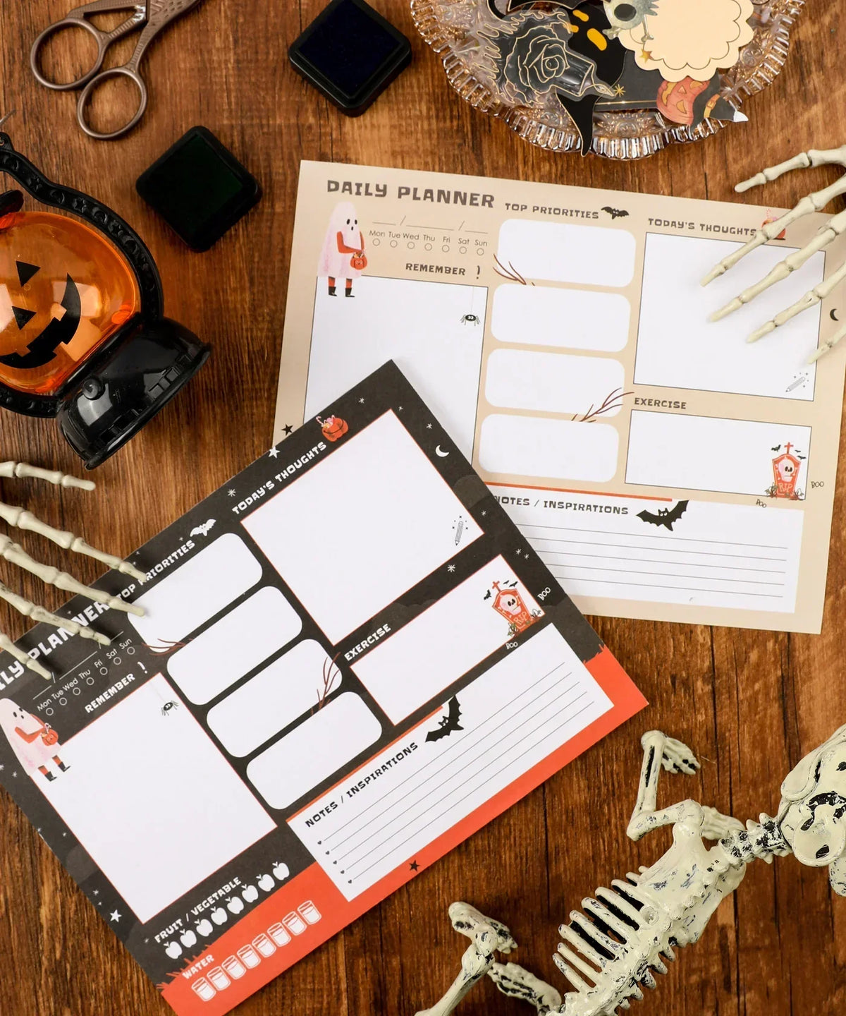 30 sheets Halloween Exclusive Daily Planner with spooky illustrations on wooden desk surrounded by craft supplies and skeleton props