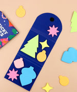Colorful holiday-shaped sticky notes arranged inside a blue holder for A Pocket Full Of Happiness Sticky Notes
