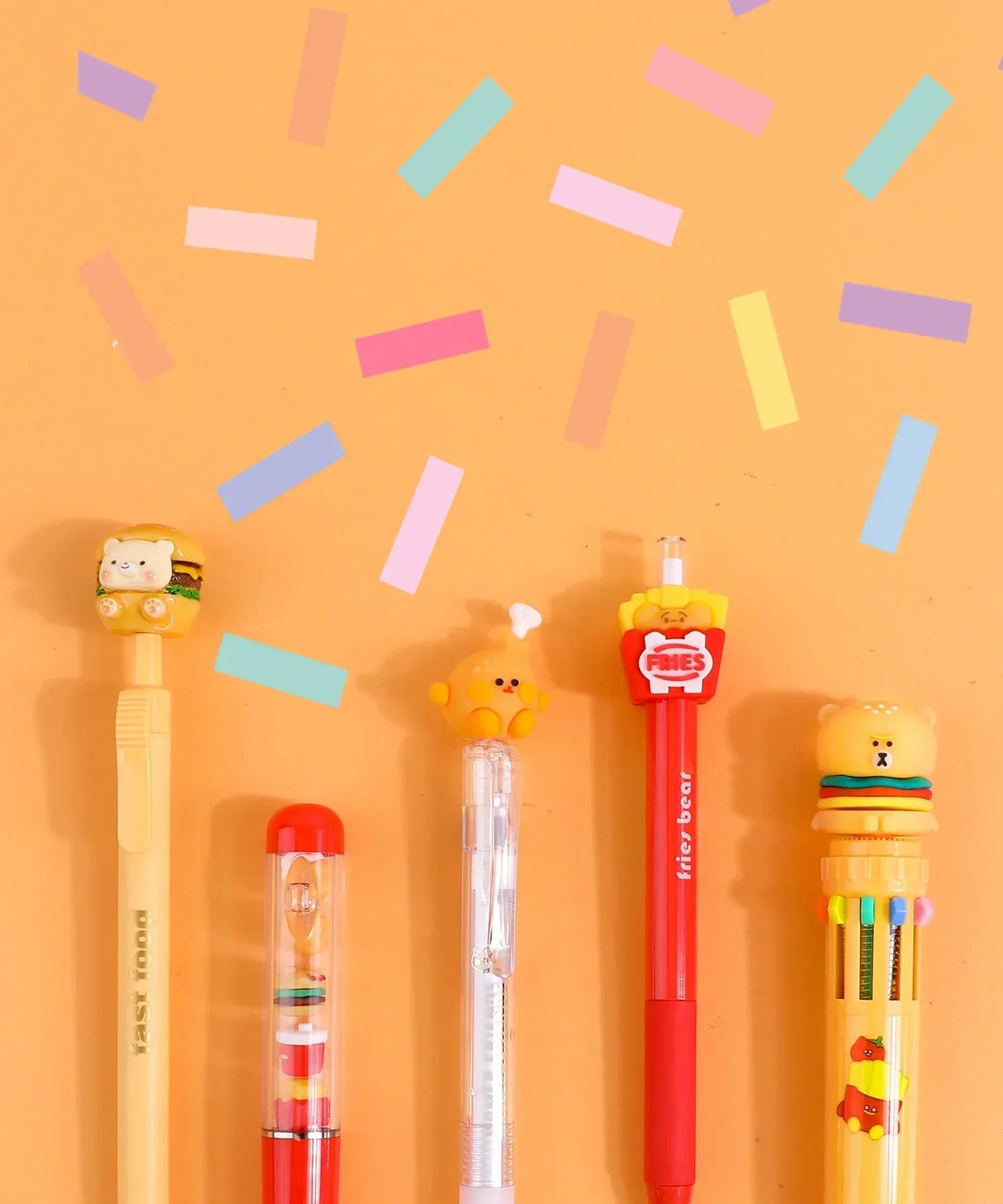 Mouthwatering Foodie Stationery Set Of 9 colorful pens with food-themed toppers and playful confetti background