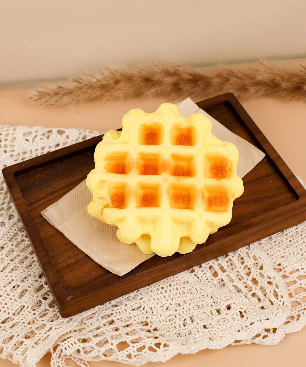 Feel-Good Stress Relief Foam Squishy - Waffle Sandwich placed on wooden tray with doily and dried grasses background