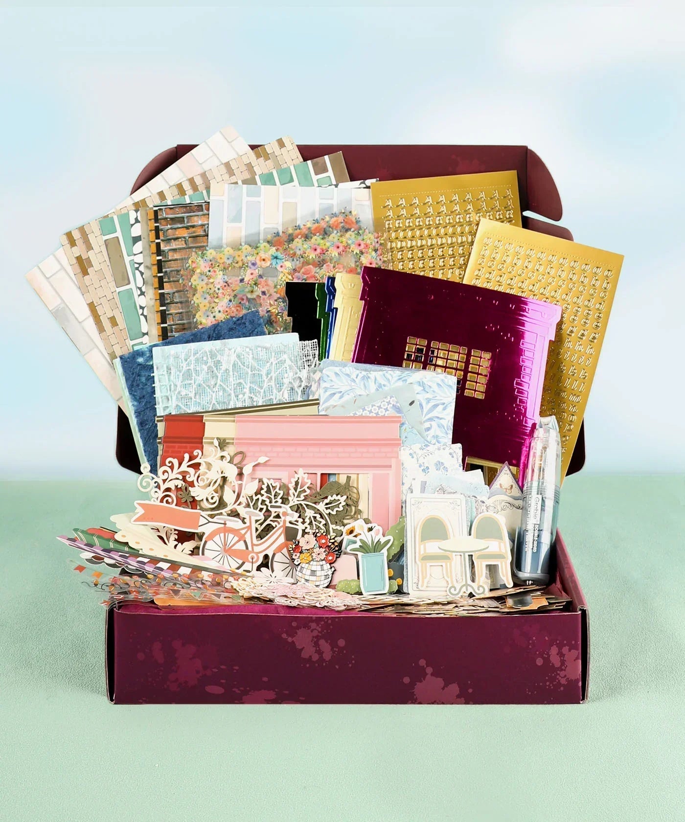 Cozy Pop Stores-Themed Grabie Scrapbook Club Box with decorative papers, stickers, and art supplies for scrapbooking projects