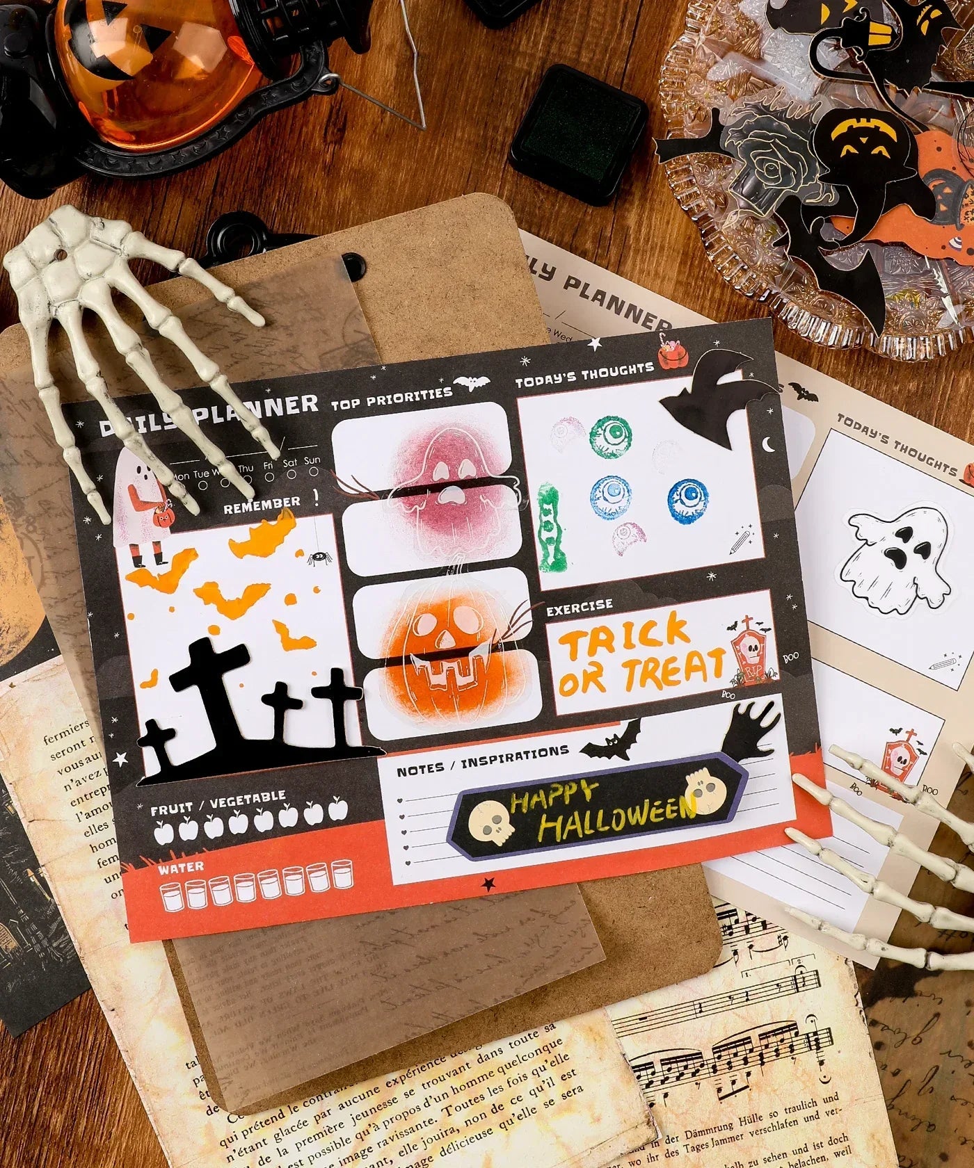 30 sheets Halloween Exclusive Daily Planner with spooky designs and sections for notes and priorities on a wooden desk