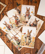 Grabie Exclusive 6 Pack Postcards With 6 Matching Envelopes featuring watercolor rabbits in vintage attire on wood surface.