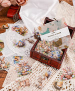 60 Pcs Grabie Exclusive The Magic Of Easter Sticker Set with Easter-themed animal and egg designs on lace and wooden box background