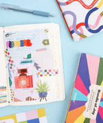 60 Sheets Grabie Exclusive Bundle Of Joy Desktop Notepad Jotter with pen and colorful scrapbook supplies on blue background
