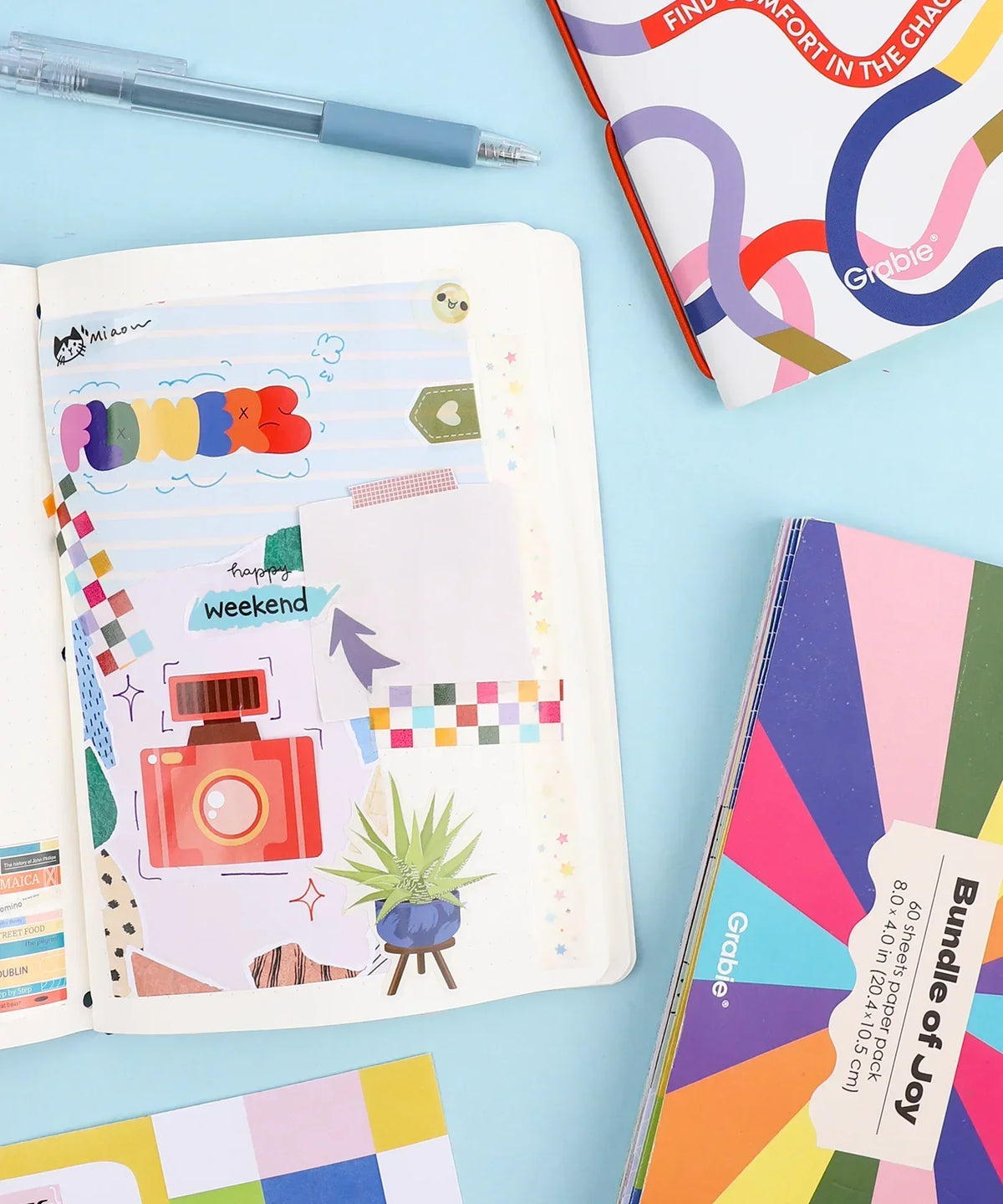 60 Sheets Grabie Exclusive Bundle Of Joy Desktop Notepad Jotter with pen and colorful scrapbook supplies on blue background