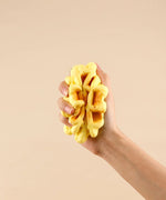 Hand squeezing a soft yellow foam waffle toy designed as Feel-Good Stress Relief Foam Squishy - Waffle Sandwich