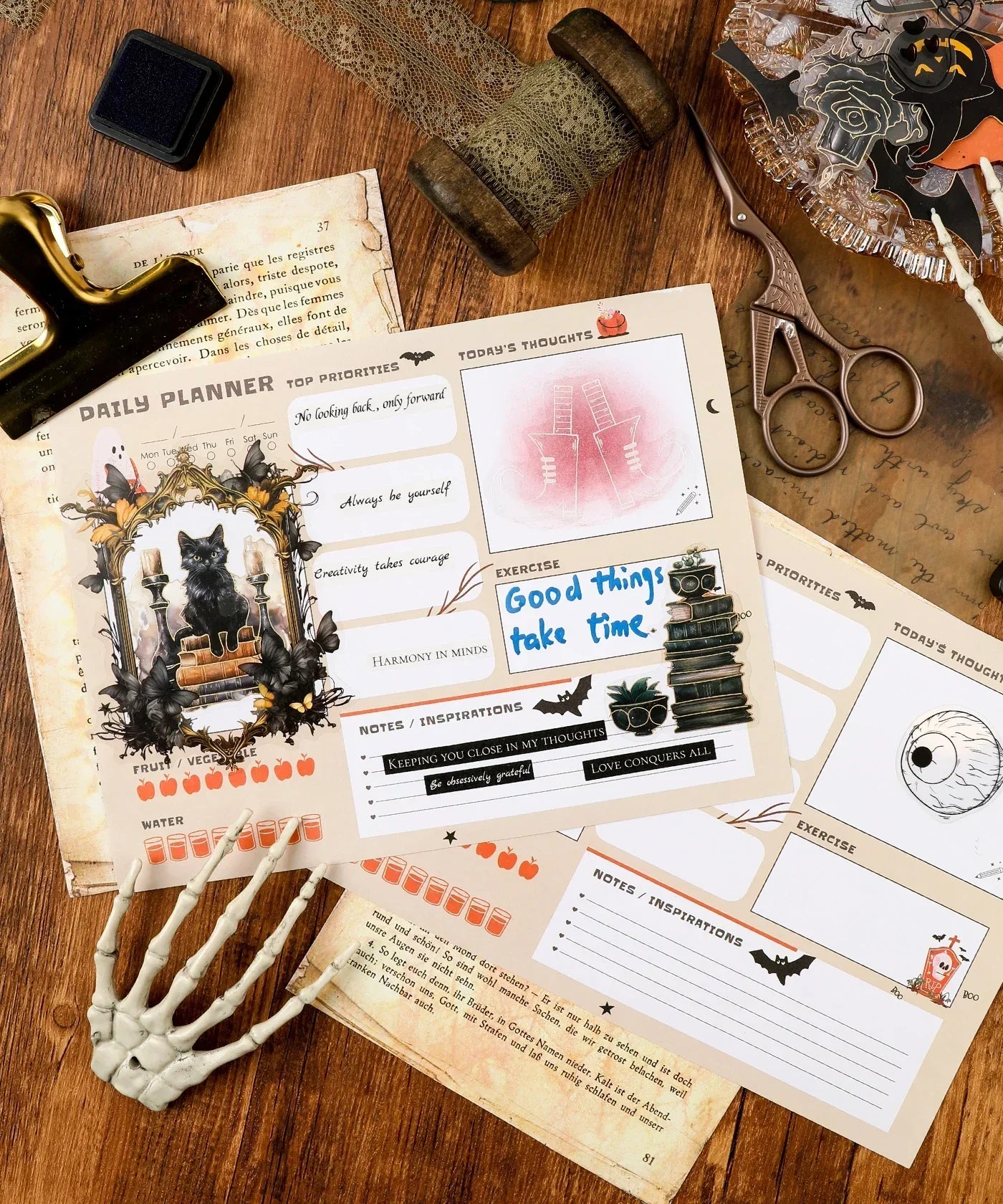 30 sheets Halloween Exclusive Daily Planner open on table with vintage scissors, ink pad, and skeleton hand decoration