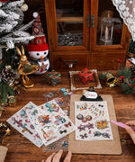 Hands peeling stickers from 8 Sheets Grabie Exclusive New Year Sticker Set on wood table with festive decor