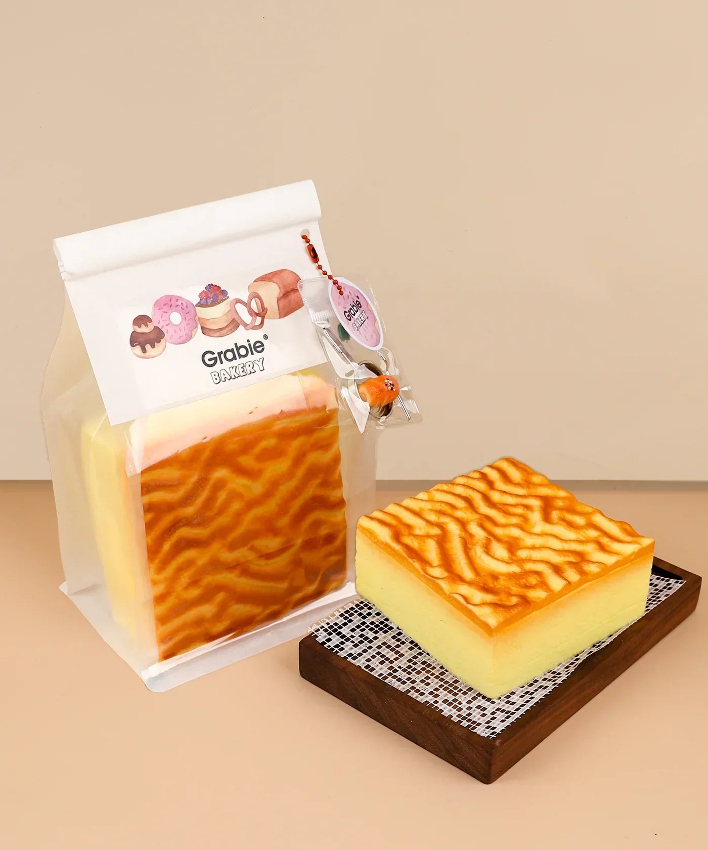 Feel-Good Stress Relief Foam Squishy - Tiger Skin Cake displayed on a wooden tray next to packaging with bakery illustrations.