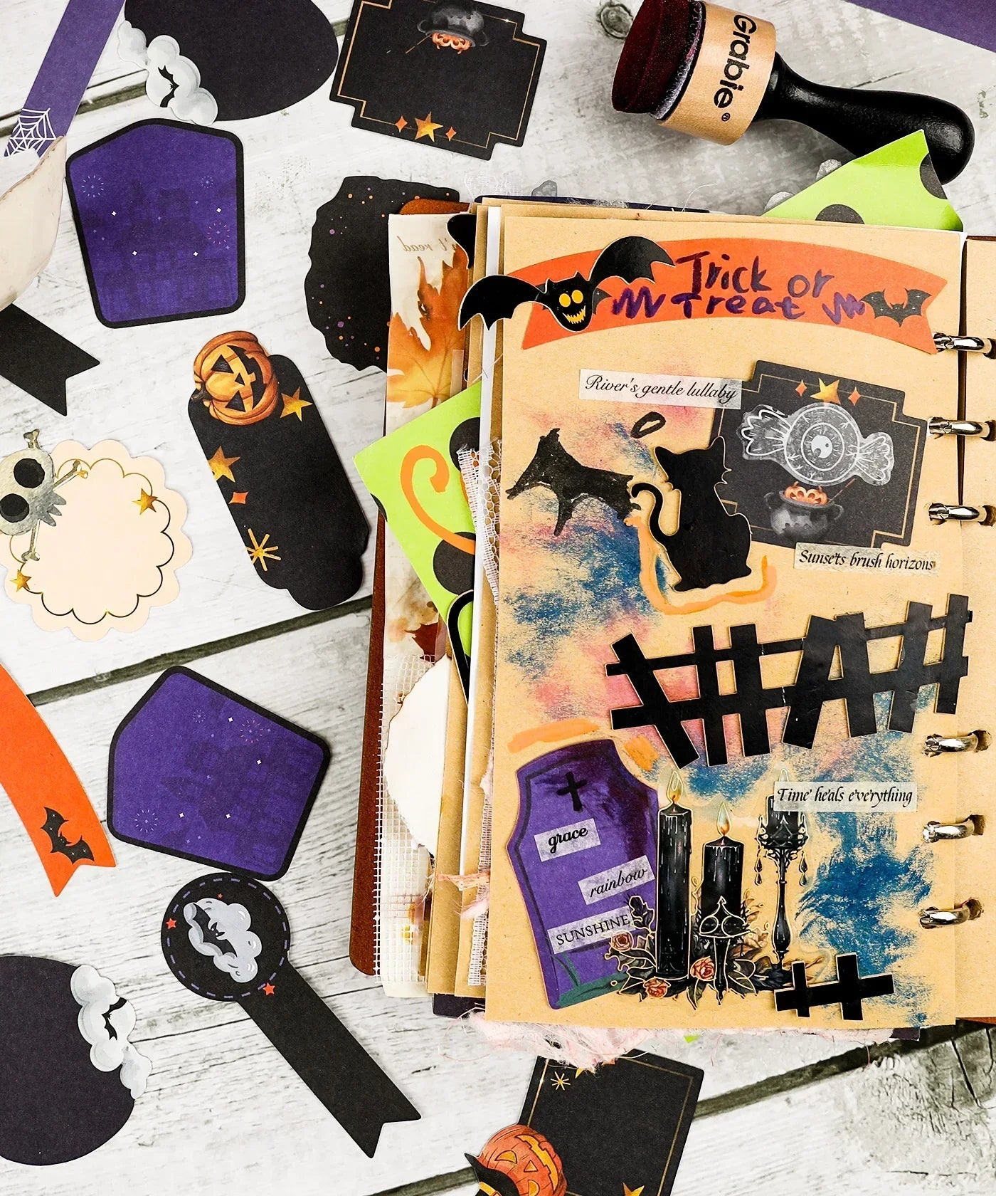 22 Pcs Grabie Exclusive Happy Haunting Sticker Set displayed on an open scrapbook with Halloween-themed designs and art supplies
