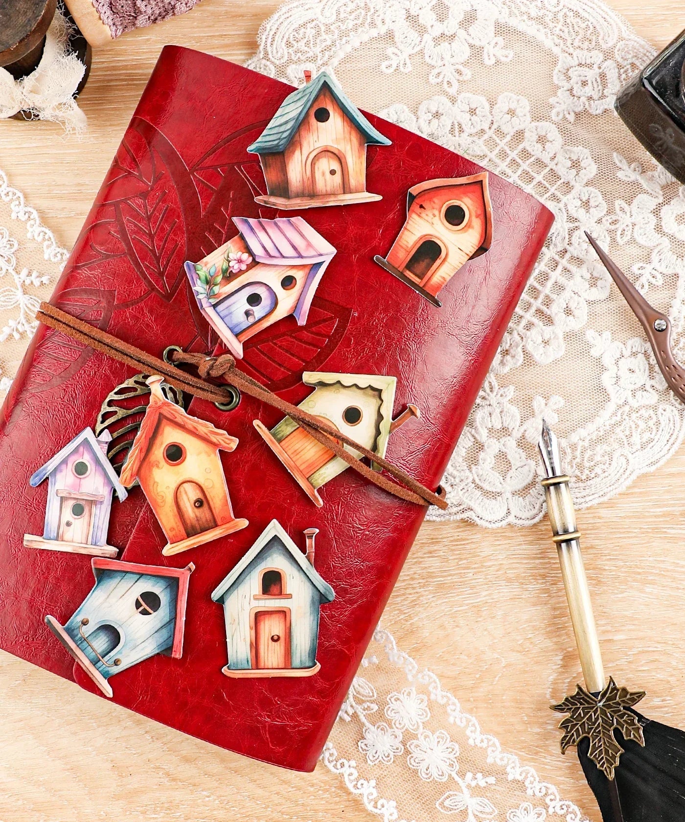 20 Pcs Grabie Exclusive Fairybird House Sticker Set arranged on a vintage red leather journal with pen and lace details