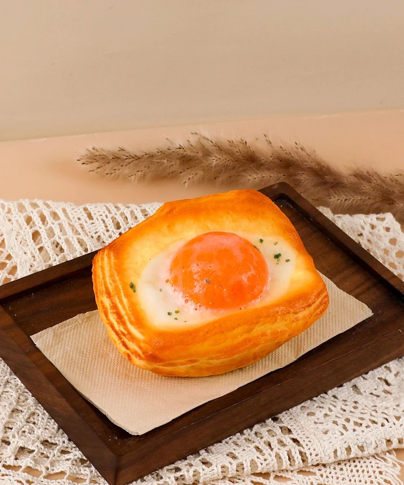 Soft stress relief foam squishy shaped like a fried egg bun with realistic orange yolk and toasted bread edges.