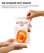 Hands holding packaging with Feel-Good Stress Relief Foam Squishy - Fried Egg Bun inside and small charm attached
