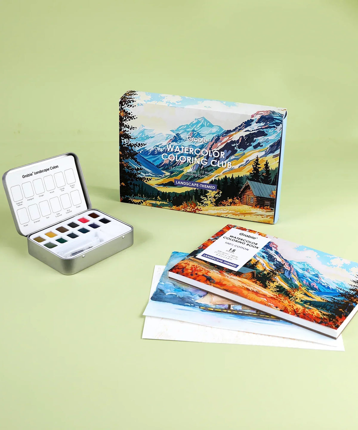Landscape-Themed Watercolor Coloring Club Box with watercolor palette and landscape-themed coloring books on green background