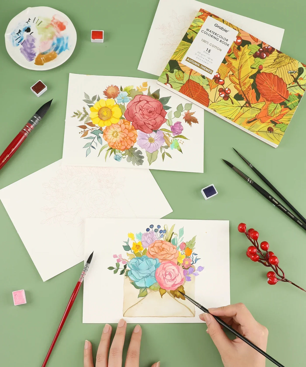 Autumn-Themed Watercolor Coloring Club Box with floral paintings, brushes, and watercolor paints on green background