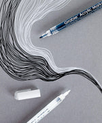 Extra Fine Tip Acrylic Paint Marker Set Of 6 with black and white ink creating detailed flowing lines on gray paper.
