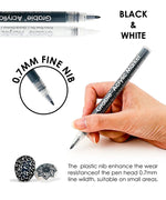 Grabie Acrylic Paint Marker Set showing black and white markers with 0.7mm fine nib held in hand for detail work