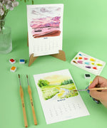 2026 Watercolor Calendar & Creative Tools Set with brushes, watercolor paints, and nature-inspired calendar designs on green background