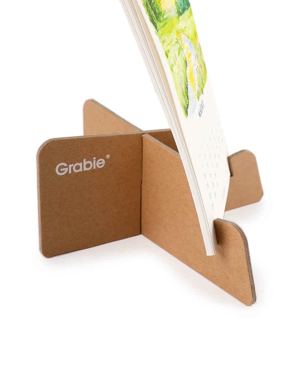 Minimalist cardboard easel holding the 2026 Watercolor Calendar & Creative Tools Set with watercolor art visible.