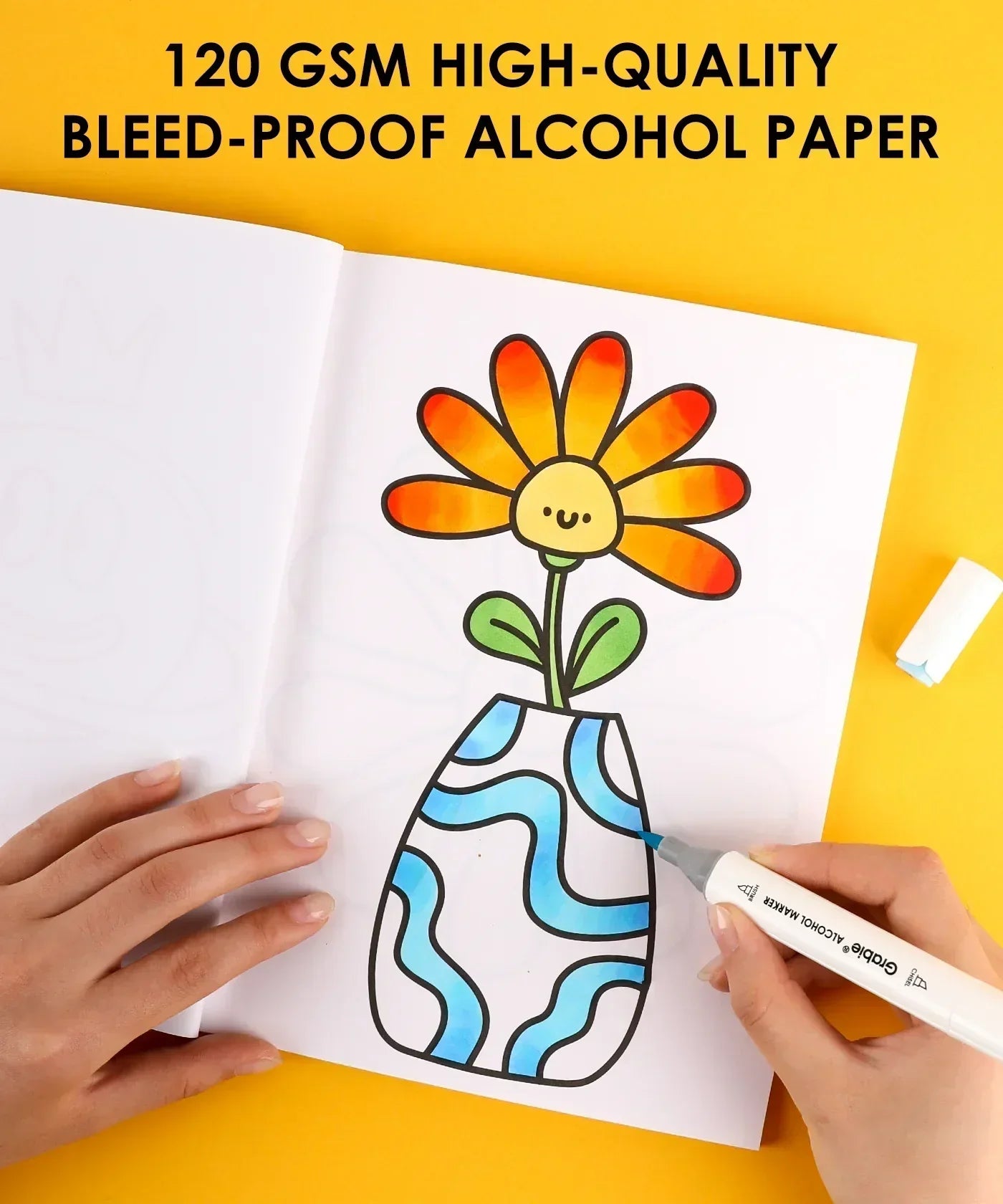 Hand coloring a flower vase illustration in a book using Dual Tone Brush Tip Acrylic Paint Marker Set With Coloring Book on yellow background