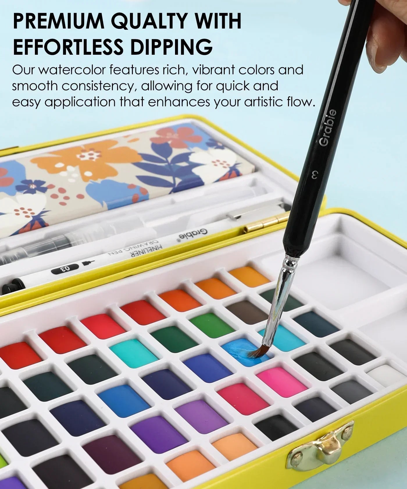 Hand dipping brush into vibrant watercolor palette in 2026 Watercolor Calendar & Creative Tools Set for smooth artistic flow