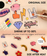 Colorful shrinkable plastic charms and markers for Shrink to Sparkles Craft Kit (DIY Shrinky Dinks Set) with art supplies displayed. 