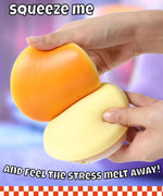 Hands squeezing a soft orange and yellow Grabie Ultimate Stress Relief Squishy to relieve stress and tension