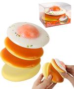 Grabie Ultimate Stress Relief Squishy shaped like a stack of pancakes with a fried egg on top being squeezed by hands