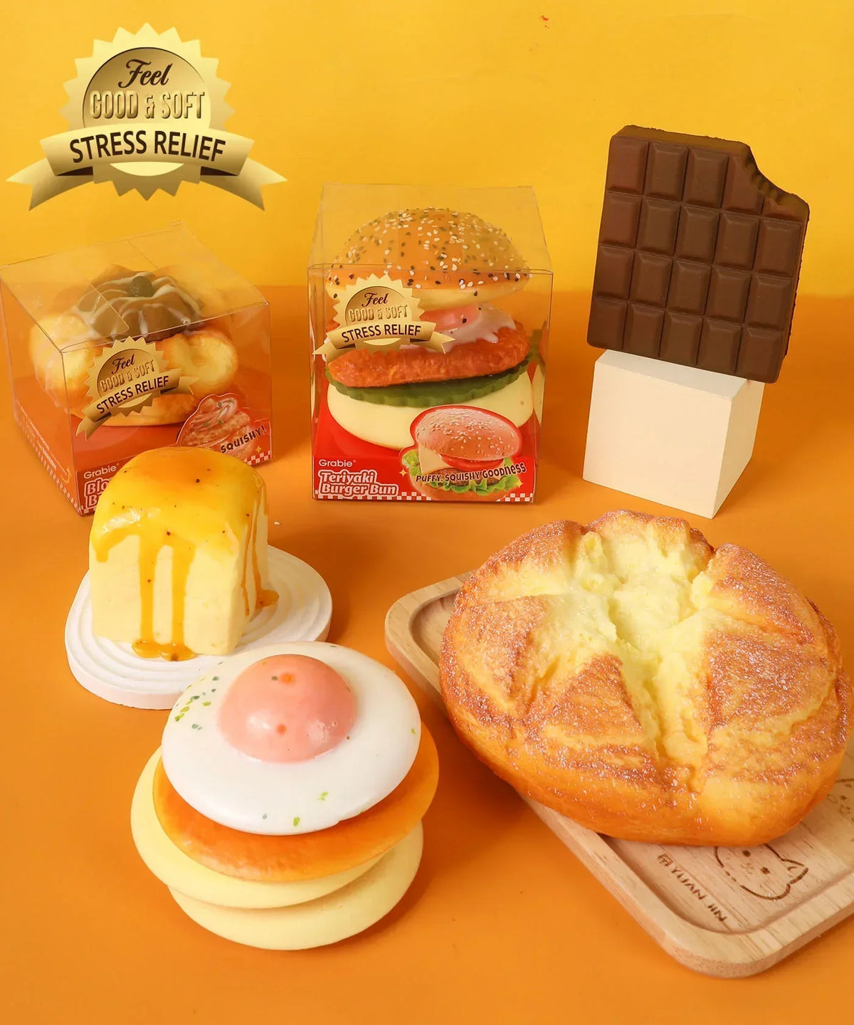 Assorted Grabie Ultimate Stress Relief Squishy toys shaped like food items including burger, chocolate, and dessert treats.