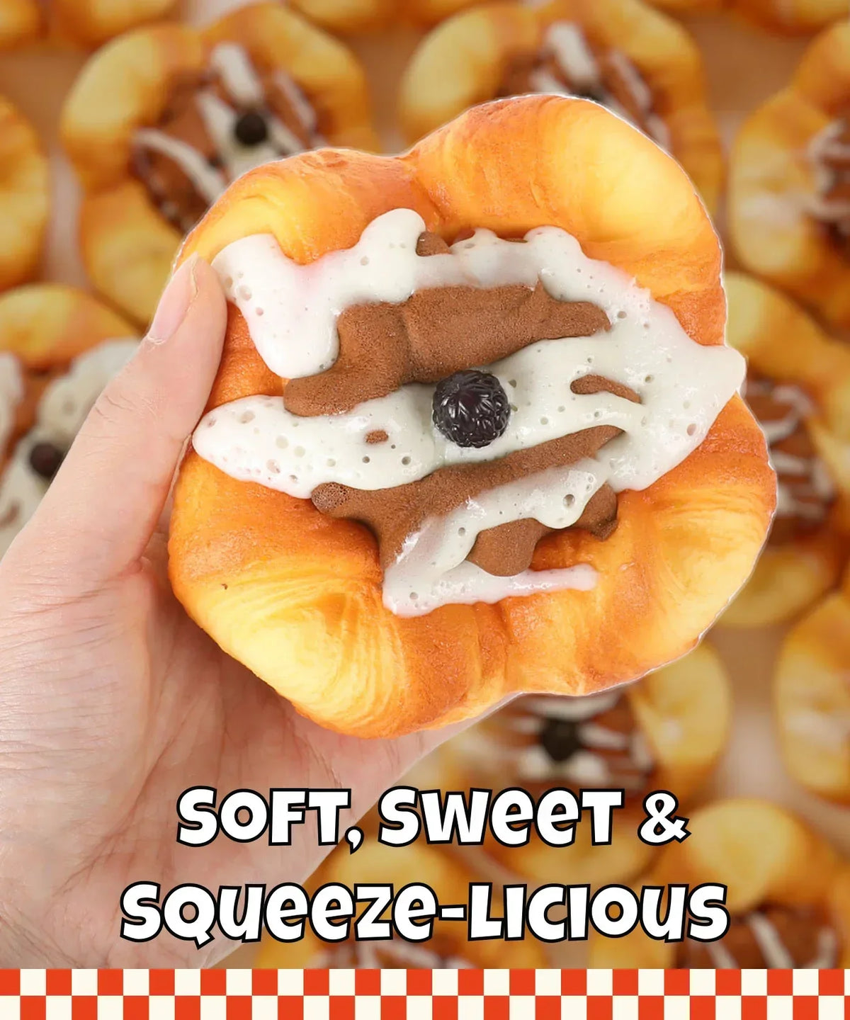 Hand holding a realistic squishy dessert toy with icing and a berry, Grabie Ultimate Stress Relief Squishy.