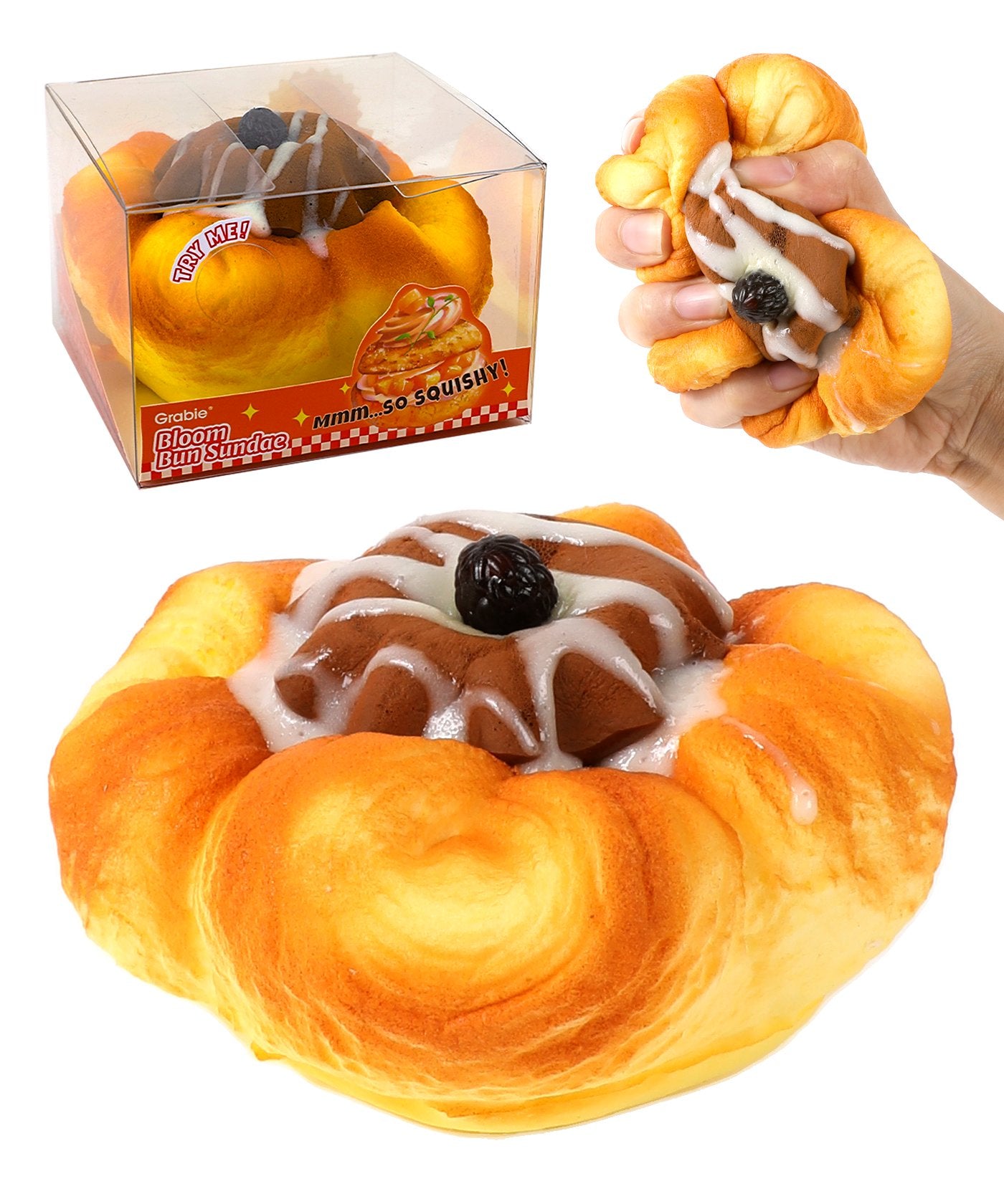 Hand squeezing a dessert-shaped Grabie Ultimate Stress Relief Squishy resembling a bun with icing and a cherry on top.