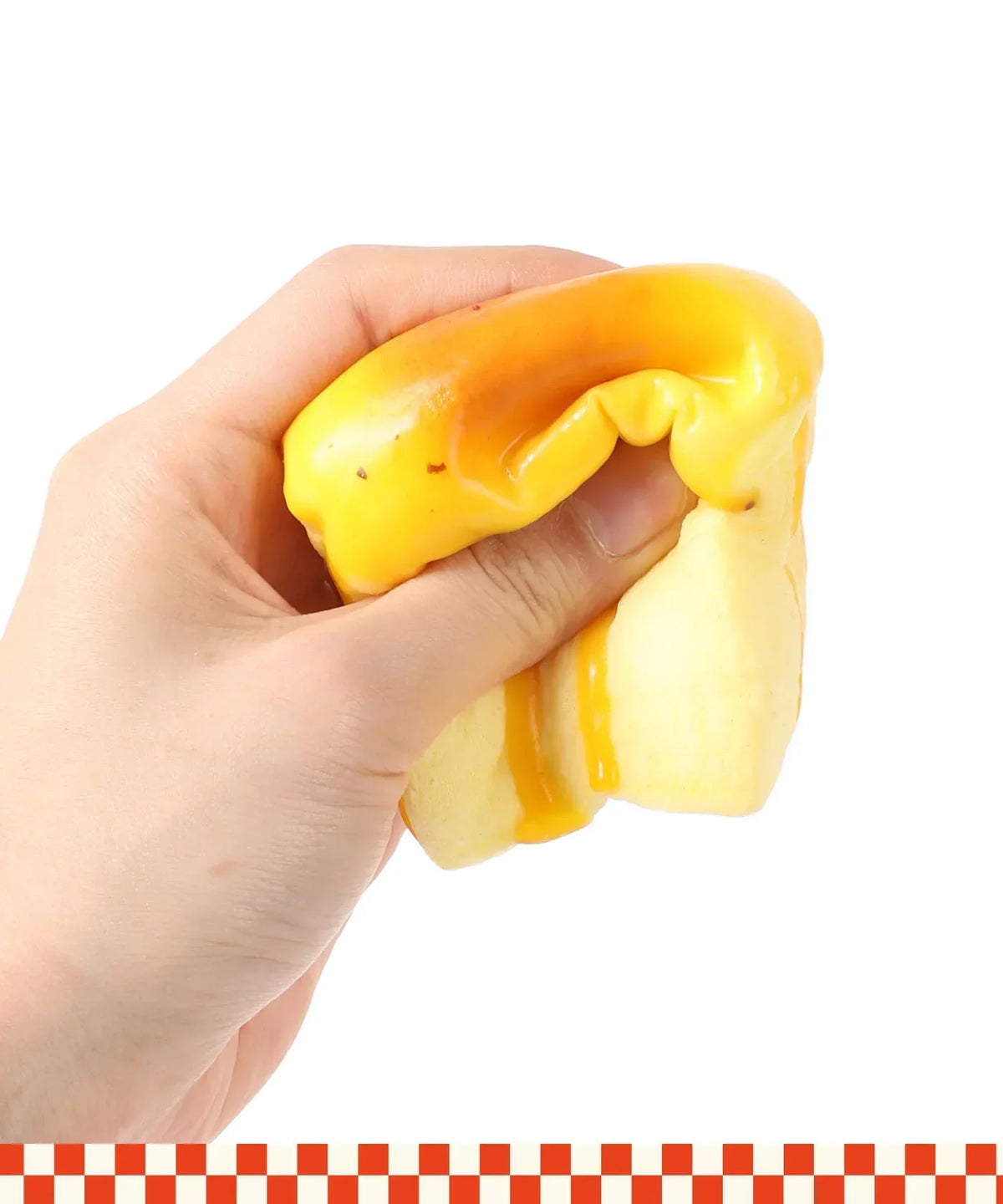 Hand squeezing bright yellow and orange Grabie Ultimate Stress Relief Squishy toy against white background