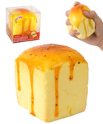 Grabie Ultimate Stress Relief Squishy shaped like a melting butter cube with yellow and orange details in hand and packaging.