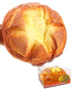 Hand squeezing a soft, yellow bread-shaped Grabie Ultimate Stress Relief Squishy toy with detailed texture and a clear display box below.