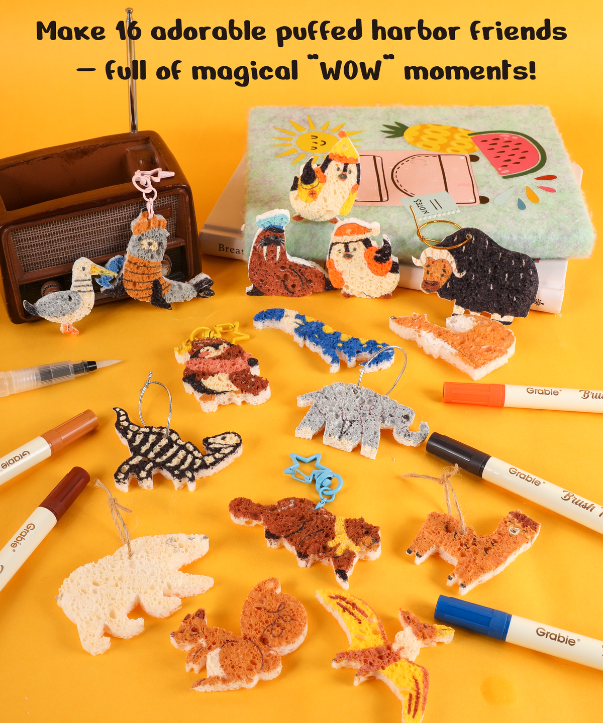 Various colorful puffed animal characters and markers arranged on yellow surface with a book, showcasing Drop to Puff 3D Sponge Art Kit..