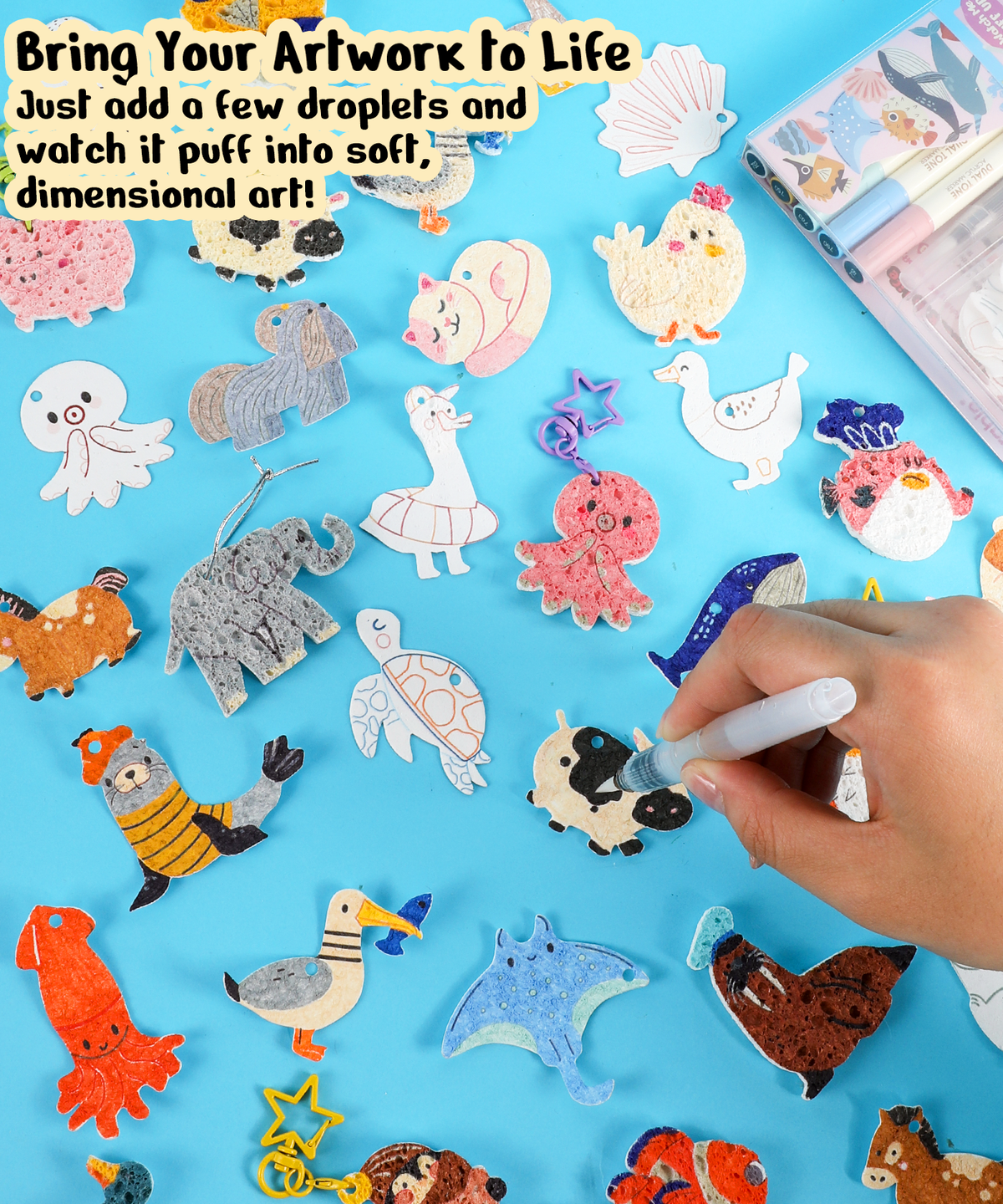 Hand adding color to textured animal shapes with Drop to Puff 3D Sponge Art Kit and art supplies on blue surface