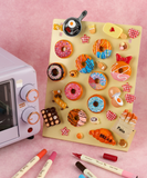 Colorful handmade magnets of donuts, bread, and breakfast items displayed on board with Magnet Painting Kit (DIY Refrigerator Magnet Kit)