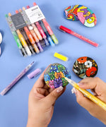 Artist using Extra Fine Tip Acrylic Paint Marker Set With Iridescent Glitter Acrylic Paint Marker Set to paint colorful designs on stones